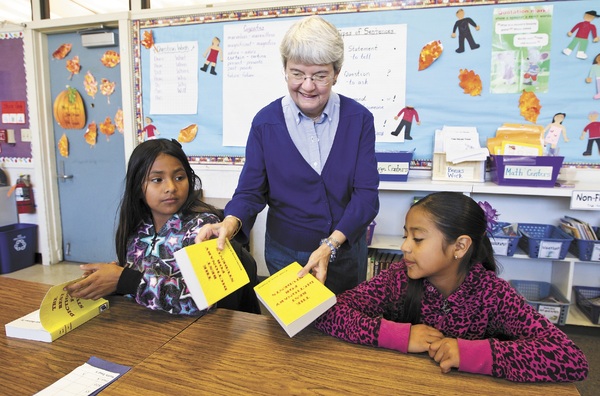 Ms. Linda Keetch of Pismo Beach, California presents dictionaries to two students.