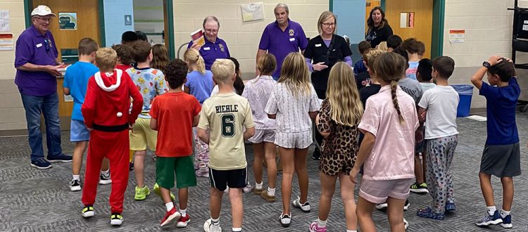 Lions Steve Hall, Rob Ginder, Craig Cooley, and Dr. Kathleen Busby pass out dictionaries. (Photo provided by Westfield Lions Club)
